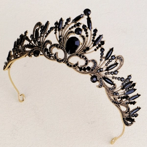 Detailed macro shot of vintage gold crown with black crystals and baroque patterns