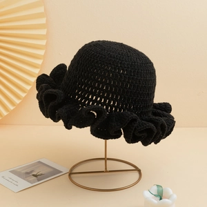 Minimalist black crochet knit bucket hat featuring wide ruffled brim in elegant studio shot