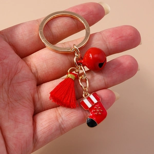 Detailed close-up of a Christmas keychain featuring a red tassel and bell with a stocking charm