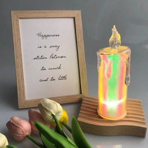 Iridescent LED electronic candle with flickering flame on a wavy wooden base