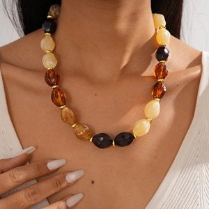 Detailed view of bohemian acrylic beaded necklace with amber and black geometric stones