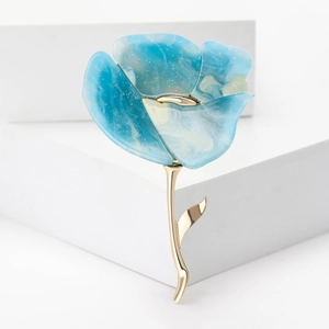 Detail van het blauwe marmerhars bloemblad en de gouden metalen steel van de broche