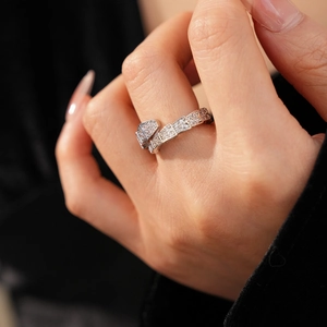 Detailed close-up of a silver snake ring with cubic zirconia on a model's hand