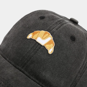 Close-up of premium croissant embroidery on washed cotton dark gray baseball cap