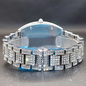 Macro detail of silver tone metal watch band with full crystal pavé setting and folding clasp