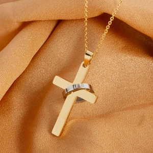 Hip hop gold cross pendant necklace with silver ring accent on yellow silk background