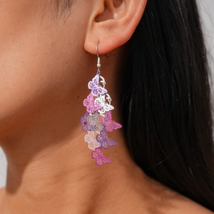 Detail of hollow butterfly tassel earrings with pink and purple gradient metallic finish