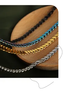 Detailed close-up of interlocking scale link chains in black, rainbow, gold, and silver finishes