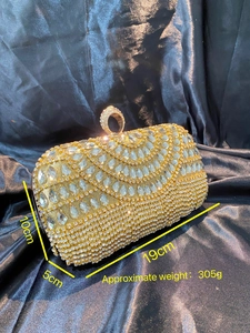 Detailed view of a gold rhinestone evening clutch with dimensions 19x10x5cm and 305g weight