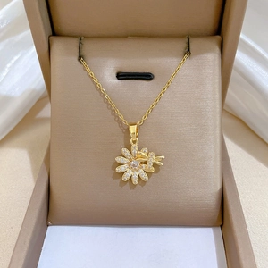 Detailed view of daisy and dragonfly pendant necklace with micro-pave crystals