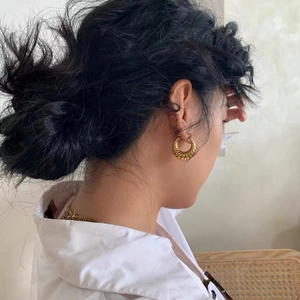 Minimalist golden titanium steel croissant hoop earrings with ribbed texture on female model