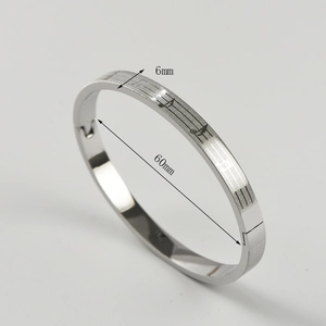 Detail showing 6mm width and 60mm diameter of silver steel bracelet with music notes