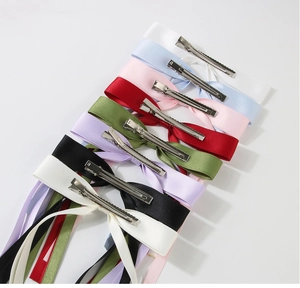 Detail of colorful ribbon bow hair clips with metal duckbill grips in various pastel colors