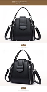 Detail view of black matte leather handbag with woven side stitching and metal snap closure