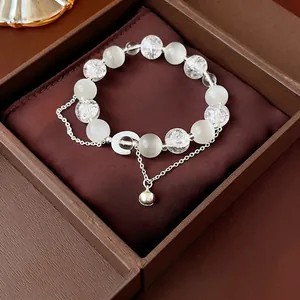 Minimalist moon beaded bracelet with white cat-eye stones, bells and silver accents