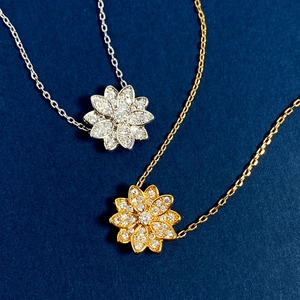 Elegant 18K gold and silver lotus flower necklaces with sparkling diamonds on blue background