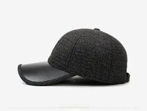 Side view detail of elderly men's winter baseball cap with grey tweed and black leather brim