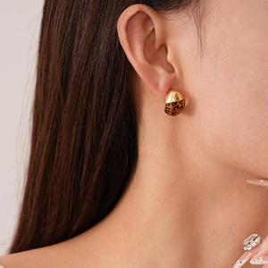 Close-up of golden leopard print earring on model featuring a sleek geometric design