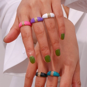 Detail of colorful enamel dome rings with gold plating and embedded small crystals