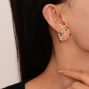 Detail von Vintage-Ohrsteckern mit Diamanten und Perlen und rosa Mittelstein