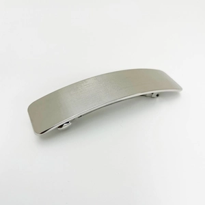 Macro detail of silver curved rectangular hair clip with fine horizontal texture