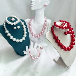 Detailed set of pearl necklace, bracelet, and earrings in white, pink, and red