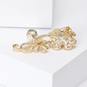 Elegant gold shell clover brooch on geometric stand with pin closure details