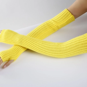 Detail view of yellow ribbed knit arm warmers with thumb holes on a white background