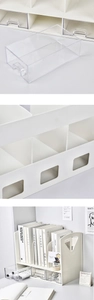 Detail view of a white desktop organizer showing storage drawers and bookshelf compartments