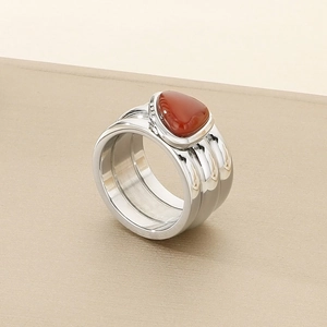 Macro shot of silver knot ring featuring a large red triangular gemstone inlay