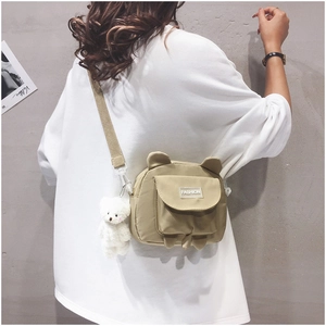 Detail of cute beige bear canvas crossbody bag with adjustable strap and bear pendant
