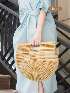Detailed close-up of handmade semi-circle hollow woven bamboo handbag in natural wood finish