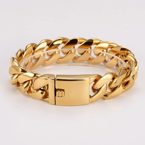 Macro shot of heavy gold Cuban link bracelet with square clasp on clear stand