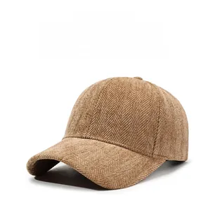 Detail shot of brown herringbone fabric texture and six-panel crown of a baseball cap