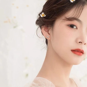 Minimalist S925 sterling silver branch stud earring worn by model with daisy hair clip