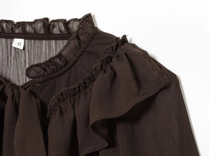 Detail of dark brown blouse featuring tiered ruffles and textured crepe chiffon fabric