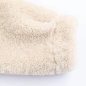 Close-up of soft cream faux fur texture on a luxury winter jacket for women