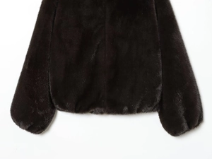 Close-up of the plush faux fur texture and elasticated hem on the dark brown bomber jacket