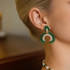 Elegantes pendientes vintage de cristal verde con detalles de pedrería en una modelo