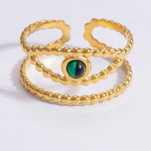 Detail of 18k gold double-layer wave ring featuring a round green cat eye gemstone