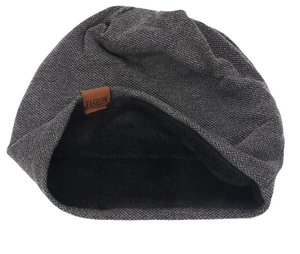 Dettaglio del cappello in maglia invernale con fodera in pile e etichetta in pelle marrone