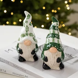 Ceramic Christmas gnome figurine set with forest green hats on decorative books
