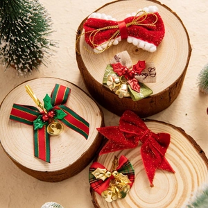 Christmas bow hair clips with velvet ribbons and metal bells on wooden background