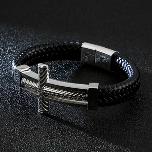 Detailed macro view of black braided leather bracelet with silver steel cross element