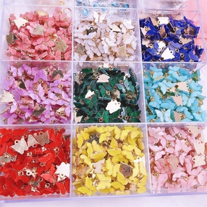 Detailed view of colorful acrylic butterfly charms with gold metal rings for DIY jewelry