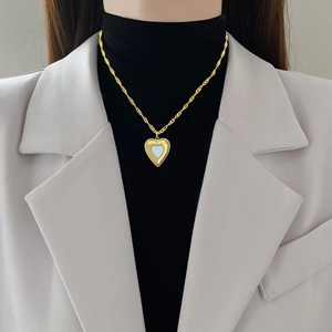 Minimalist gold heart necklace with white shell inlay worn on a model's neck