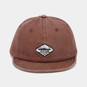 Close-up of brown washed cotton short brim hat with mountain embroidery patch detail