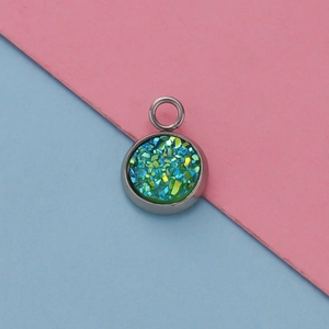 Macro shot of 12mm stainless steel pendant base with sparkling green and blue resin inlay