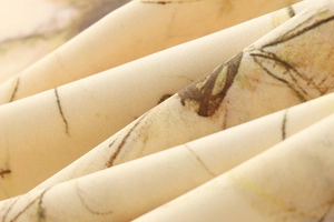 Gros plan sur le tissu de la robe longue dos nu beige avec imprimé floral