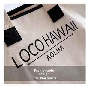 Detailansicht der Canvas-Tasche mit verstärkten schwarzen Griffen und aufgedrucktem Text